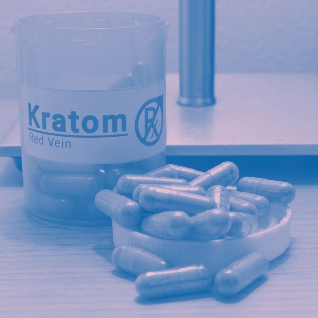 Bottle of Kratom Capsules and capsules on table