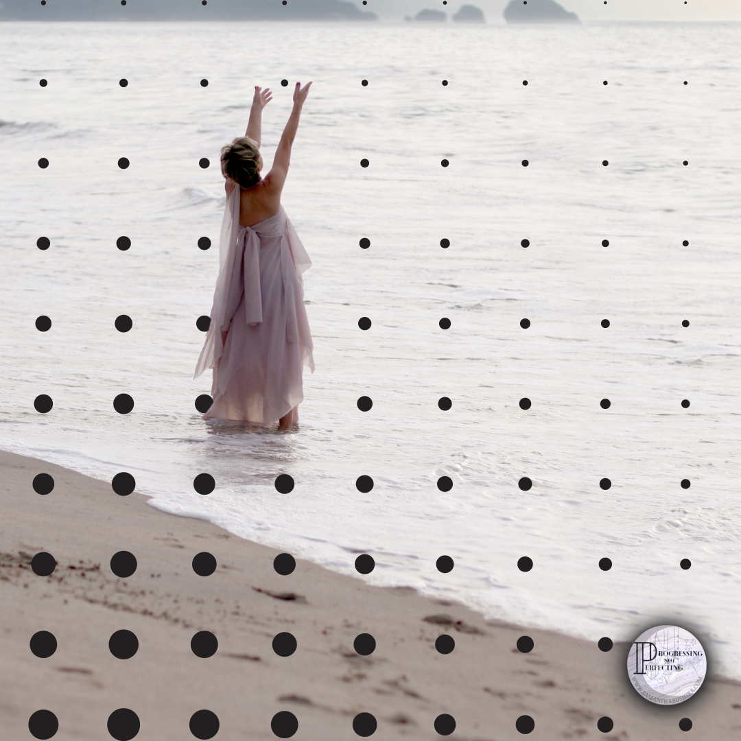 a woman in a dress standing in the water