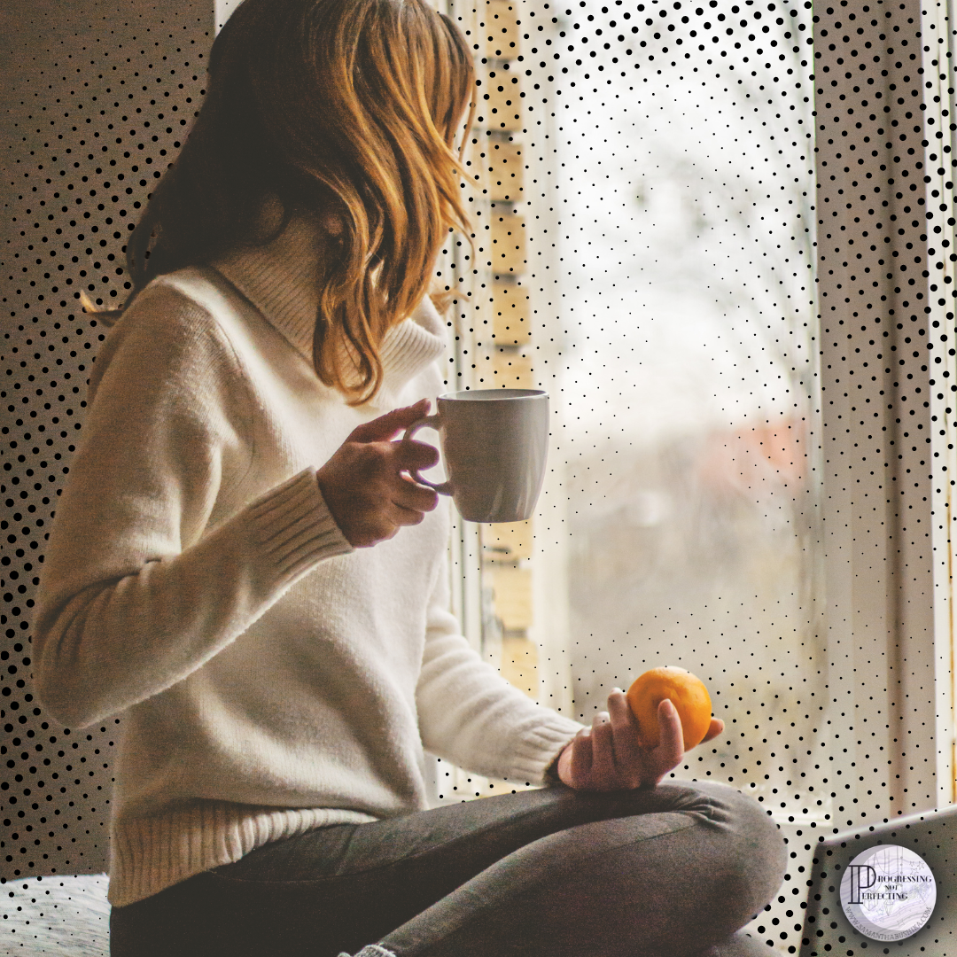 woman with coffee in front of window